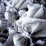 Μπομπονιέρα γάμου λινή με τελείωμα δαντέλα σε απόχρωση της άμμου και δέσιμο με στριφτό λευκό κορδόνι