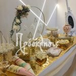 Στολισμός τραπέζι ευχών γάμου με χρυσά πολύγωνα και φλοραλ